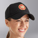 A woman wearing a black Choice 6-panel cap with a logo.