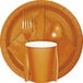A white table with a Pumpkin Spice Orange table cover with a plate, fork, and knife.