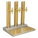 A Micro Matic brass tower with three golden pipes.