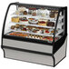A True refrigerated bakery display case with a variety of cakes on display.