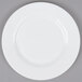 A white Arcoroc Zenix Intensity salad plate with a white rim on a gray surface.