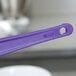A Rubbermaid purple silicone spatula with a purple plastic handle.