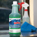 A bottle of Noble Chemical Reflect Super Concentrated Window Cleaner on a counter.
