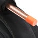 A close up of a copper tube with black rubber hoses and orange tips.