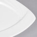 A CAC Garden State bone white porcelain square plate with curved edges.