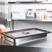 A black silicone band around a stainless steel steam table pan on a counter.