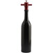 A black wine bottle pepper mill with a white lid and red handle.