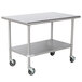 A stainless steel Advance Tabco work table with casters and an undershelf.