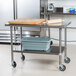 An Advance Tabco stainless steel work table with undershelf and casters.