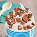 A cup of ice cream with Chopped Brown & Haley Almond Roca Topping and whipped cream.