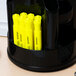 A black pen holder with a yellow Universal chisel tip highlighter on a counter.