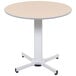 A Luxor round pneumatic adjustable height table with a white base.