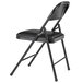 A National Public Seating black metal folding chair with black padded vinyl seat.