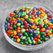 A bowl of chocolate-covered sunflower seed candy gems in different colors.