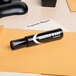 A black Avery Marks-A-Lot desk style permanent marker with a chisel tip on a yellow envelope.