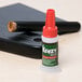 A green and white Krazy Glue bottle with a red cap and brush applicator.