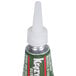 A close-up of a green and white Krazy Glue tube with a white cap.