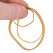 A hand holding a Universal beige rubber band.