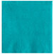 A teal beverage napkin with a white spot.