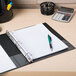 A black Avery Durable binder with a pen on a desk.