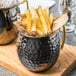 An American Metalcraft hammered black Moscow Mule mug filled with french fries.