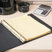 A Universal binder with Universal Leather-Look Month Tab Dividers on a table with a calculator.