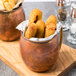 Two American Metalcraft antique copper mugs filled with fried fish and chips.