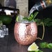 An American Metalcraft copper Moscow Mule mug filled with ice and a lime.