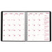 The open planner showing a white calendar page with black and pink text.