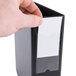 A hand holding a black Universal non-view binder with a white label.