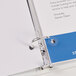 A white binder with Avery clear hole reinforcement labels on white paper.