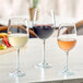 Acopa Select Flora wine glasses on a table with fruit and vegetables.