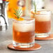Two Acopa rocks glasses of whiskey with rosemary garnish.
