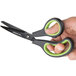 A person using Universal 8" Carbon-Coated Industrial Scissors with black and green bent handles.