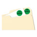 A file folder with two green round Avery labels on it.
