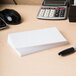 A white Universal 4" x 6" unruled index card sits on a table next to a pen and calculator.