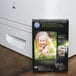 A black box of HP Inc. Glossy Photo Paper with green text and a picture of a girl on it.