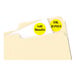 A file folder with Avery yellow round labels on it.