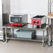 An Advance Tabco stainless steel equipment stand with an undershelf.