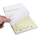 A person holding a Rediform carbonless purchase order book.