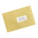 A brown envelope with a white rectangular Avery label on it.