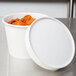 A white Double Poly-Paper soup container with a white lid on top.