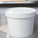 A white Double Poly-Paper soup container with a lid.