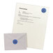 A white envelope with a blue round Avery label on it.