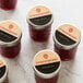 A package of Avery Kraft Brown Round Labels on a jar of strawberry jam.