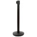 A black metal Lancaster Table & Seating crowd control stanchion with a round base.