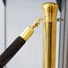 A gold pole with black rope ends on a Lancaster Table & Seating stanchion.