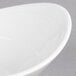 A close up of a white oval bowl with a curved rim.