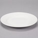 A Reserve by Libbey white porcelain plate with a wide rim on a gray surface.