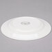 A white Reserve by Libbey round porcelain plate with a small white logo.